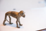Side profile view of the vintage African monkey sculpture's textured, handmade form.