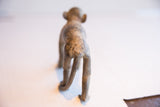 Rear view of the African monkey sculpture highlights its aged, mottled texture.