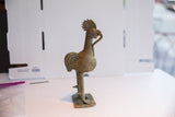 Side view of the vintage African rooster sculpture highlighting its textured body and aged patina.