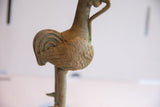 Side view of the African rooster sculpture's patinated, textured body and feathers.