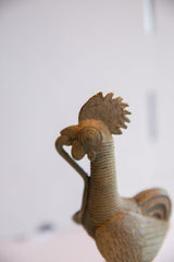 Textured comb and large eye on the patinated head of a vintage African rooster sculpture.