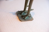 Weathered patina on the feet and etched base of the handmade African sculpture.