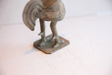 Rear view of the vintage rooster sculpture, detailing its textured legs and square base.