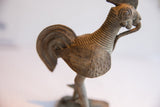 Side view of the handmade African rooster sculpture showing its textured neck and wing.