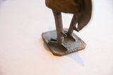 Aged metal feet and hand-marked rectangular base of the African rooster sculpture.
