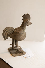 Vintage African rooster sculpture, showing its handmade texture and aged bronze patina.