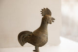 Close-up of vintage African rooster sculpture head, ribbed neck, and textured wing.