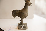 Vintage African rooster sculpture's textured wing, dotted body, and weathered metal finish.