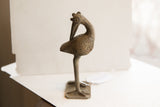 Angled profile of the vintage African bird sculpture with its head facing backwards.