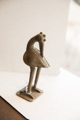 Side profile of the vintage African bird sculpture showing its handmade, textured finish.