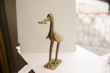 The long neck and textured body of a vintage African bird with fish sculpture.