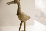 Side profile of a vintage African bird sculpture showing the textured finish and etched wing detail.
