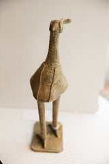 The back of a vintage African bird sculpture, detailing its handmade, textured surface.