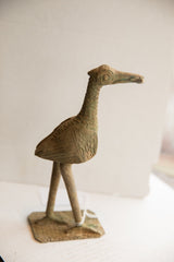 Vintage African bird sculpture in profile showing its textured patina and spiral eye design.