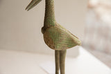 Aged patina and hand-carved feather details on the wing of the bird sculpture.