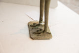 Aged patina and handmade texture on the feet and etched base of the bird sculpture.