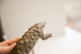Upward view of the vintage pangolin sculpture's carved face and scaled texture.