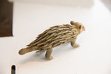 High three-quarter view of the vintage porcupine sculpture's textured body.