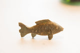 Side view of the vintage African fish figurine showing its rustic, textured patina.