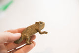 Small vintage chameleon figurine held in hand, showing its handmade textured detail and scale.