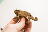 Side view of the vintage chameleon figurine held in hand, showing its textured finish.