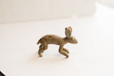 Side view of a vintage floppy-eared rabbit figurine with a rustic, patinated finish.