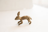 Profile view of the vintage African rabbit figurine highlighting its textured surface and aged patina.