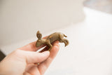 The small, handmade African rabbit figurine held in hand to show scale.