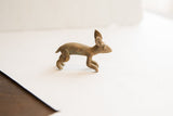 A vintage African rabbit figurine's profile, displaying its textured patina and running pose.