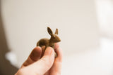 A vintage African rabbit figurine held in hand, showing its small scale and earthy texture.