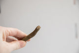 Close-up on the rustic handmade texture of a vintage African snake figurine's head.