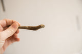 Close view of the vintage snake figurine's head showing its handmade texture and aged patina.