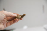 Vintage curled snake figurine held in hand to show its collectible scale and texture.