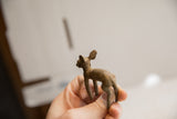 Hand-carved African ewe figurine in hand, showing its rustic, earthy texture.