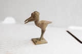 Detailed side view of the crowned African bird sculpture with an aged, textured patina.