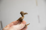 Vintage African crowned bird figurine held, showing its handcrafted texture and scale.