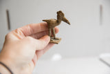 Vintage African bird figurine held in hand to show its small scale and profile.