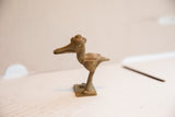 Side view of a vintage crowned bird figurine with handmade etched spiral details.