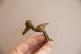 A side profile of the vintage African crowned bird highlights its unique shape and texture.