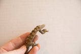 A vintage African pangolin figurine held in hand to show its collectible scale and texture.