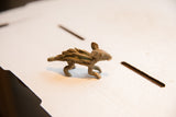 Side profile of a vintage porcupine figurine showing its textured, spiky back and patina.
