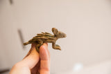 Small vintage porcupine figurine held to show its scale and oxidized texture.
