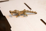 Side profile of a vintage African crocodile figurine showing its rustic, imperfect handmade texture.