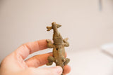 Overhead view of the vintage crocodile figurine showing its textured body and the fish in its mouth.