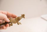 Side view of the bronze-toned crocodile figurine, showing its scale and handmade texture.