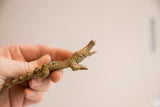 Vintage African crocodile figurine held in hand, showing its handmade texture.