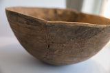 Detail of African carved wooden bowl exterior, featuring incised lines and zigzag metal repairs.