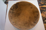 Antique African wooden bowl interior, highlighting incised zig-zag pattern and prominent cracks.
