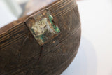 Close-up showing aged metal repair, green patina, incised geometric pattern on antique wooden bowl.