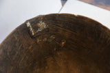 Interior detail of antique African wooden bowl, revealing aged cracks and old repairs.